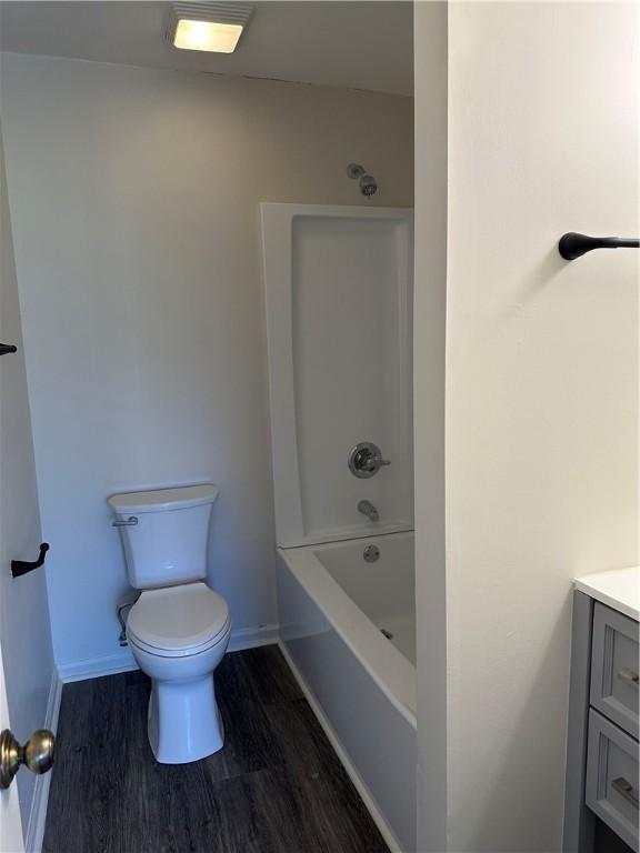 full bathroom featuring wood-type flooring, vanity, bathing tub / shower combination, and toilet