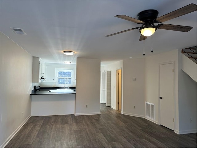 unfurnished living room with ceiling fan and dark hardwood / wood-style flooring