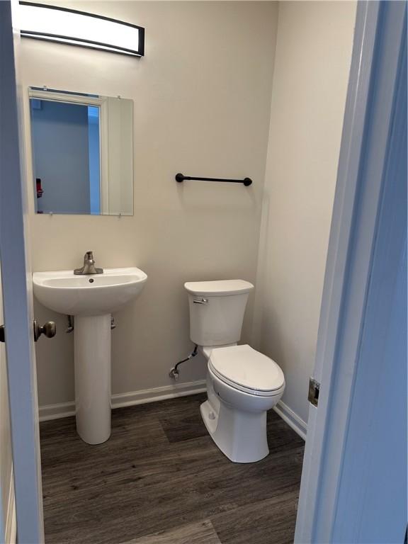 bathroom with hardwood / wood-style floors, toilet, and sink