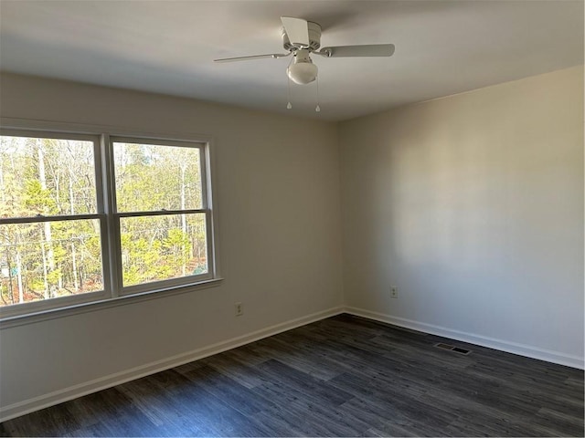 empty room featuring ceiling fan and dark hardwood / wood-style flooring