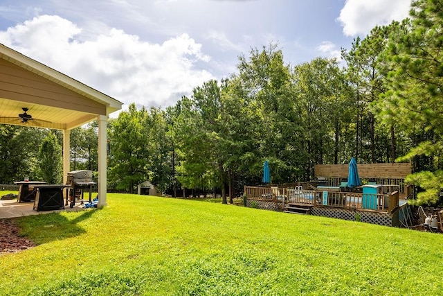 view of yard featuring a wooden deck and ceiling fan