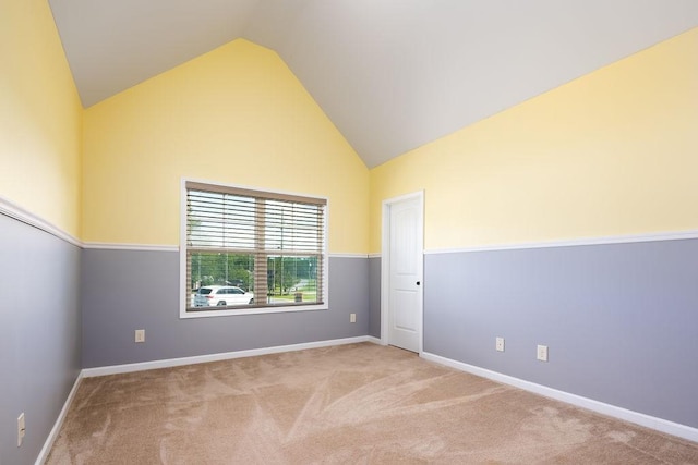 unfurnished room with lofted ceiling and light colored carpet