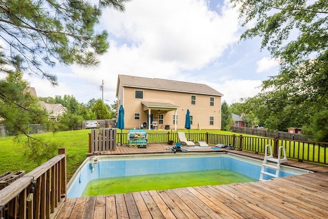 view of swimming pool featuring a deck and a lawn