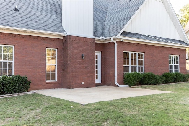 back of property with a lawn and a patio area