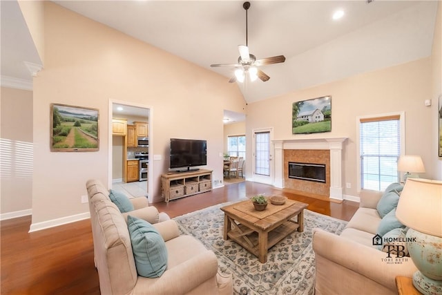 living room featuring a high end fireplace, hardwood / wood-style flooring, high vaulted ceiling, and ceiling fan