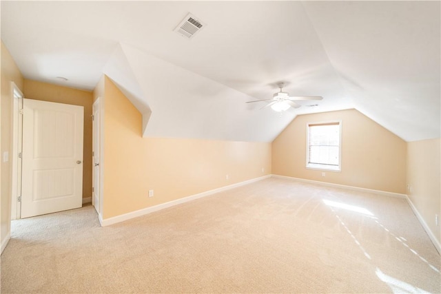 additional living space with light colored carpet, ceiling fan, and lofted ceiling