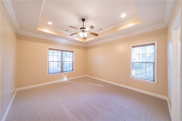 empty room with a raised ceiling, ceiling fan, and ornamental molding