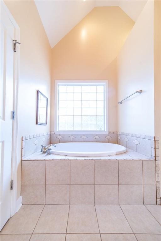 bathroom featuring tiled bath, tile patterned flooring, and lofted ceiling