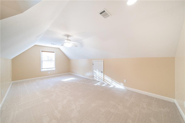 additional living space with ceiling fan, light colored carpet, and vaulted ceiling