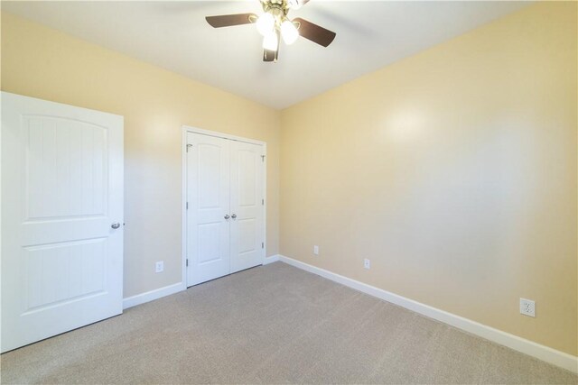 unfurnished bedroom featuring light carpet and ceiling fan