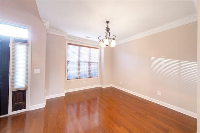 spare room featuring ornamental molding, dark hardwood / wood-style floors, and a notable chandelier