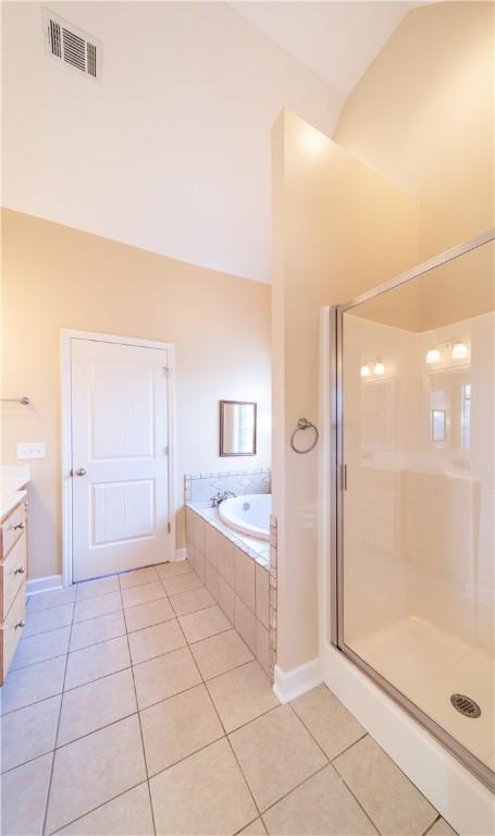 bathroom with tile patterned floors, vanity, lofted ceiling, and shower with separate bathtub