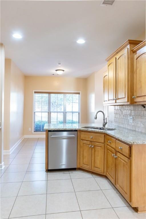 kitchen with light stone countertops, dishwasher, light tile patterned floors, and sink