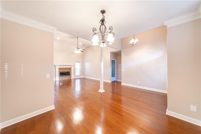 unfurnished living room with ceiling fan with notable chandelier, wood-type flooring, ornamental molding, and a high end fireplace