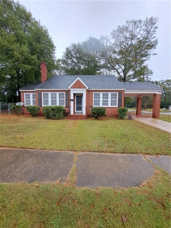 ranch-style house featuring a front yard and a carport