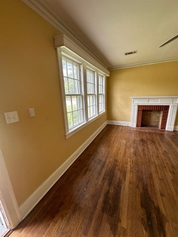 unfurnished living room with ceiling fan, hardwood / wood-style floors, ornamental molding, and a brick fireplace