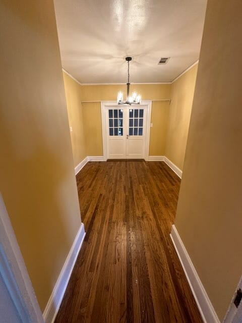 unfurnished dining area with dark hardwood / wood-style flooring and a chandelier