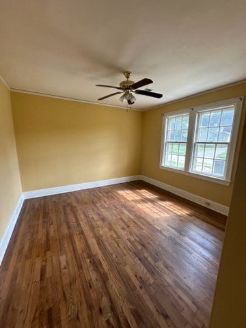 empty room with crown molding, dark hardwood / wood-style flooring, and ceiling fan