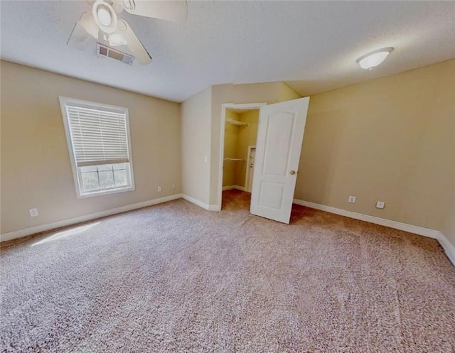 3666 Hawks Lndg, Auburn, AL 36804 - unfurnished bedroom featuring carpet floors, a walk in closet, a ceiling fan, a closet, and a textured ceiling