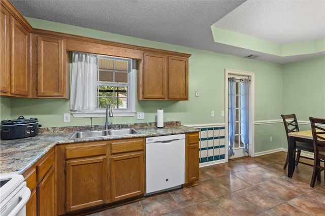 1417 Ridge Rd, Opelika, AL 36801 - kitchen featuring white appliances, brown cabinets, a textured ceiling, and dark tile patterned floors