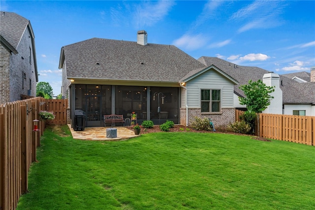 back of property with a yard, a sunroom, a patio area, and brick siding