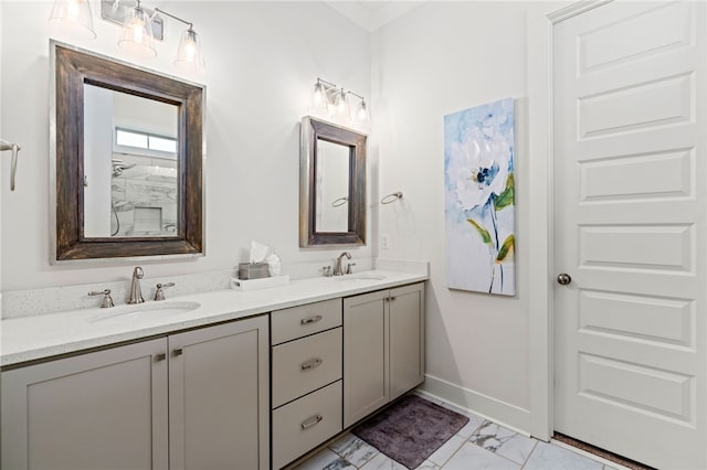 bathroom featuring marble finish floor, a sink, baseboards, and double vanity