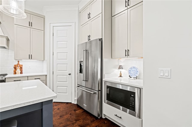 kitchen featuring black microwave, high quality fridge, ornamental molding, and decorative backsplash