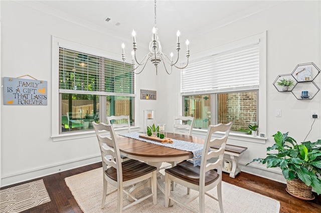 dining room featuring crown molding, a wealth of natural light, and dark wood finished floors