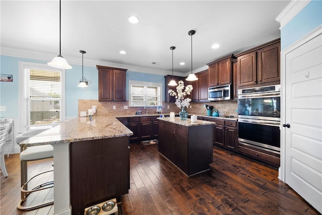 300 Holland Loop, Smiths Station, AL 36877 - kitchen with a peninsula, decorative backsplash, appliances with stainless steel finishes, ornamental molding, and a kitchen island