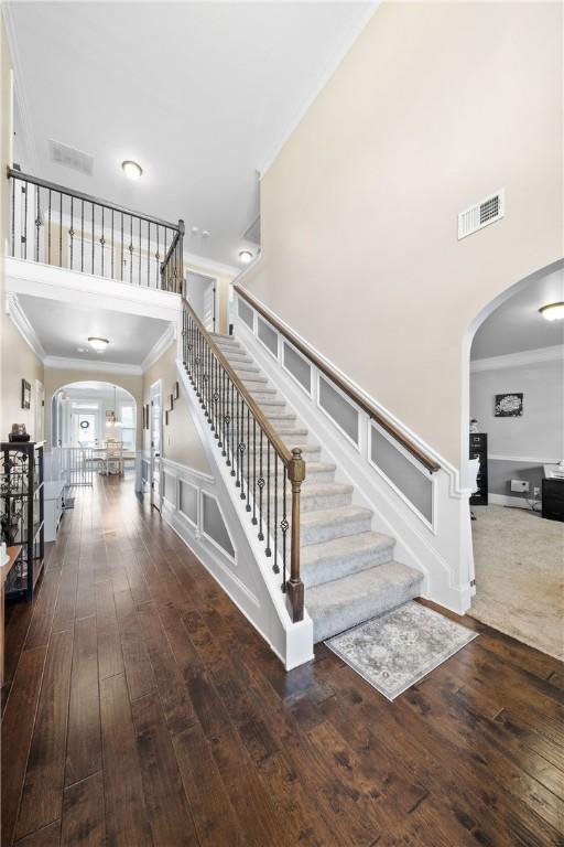 300 Holland Loop, Smiths Station, AL 36877 - staircase with arched walkways, ornamental molding, wood-type flooring, and a towering ceiling