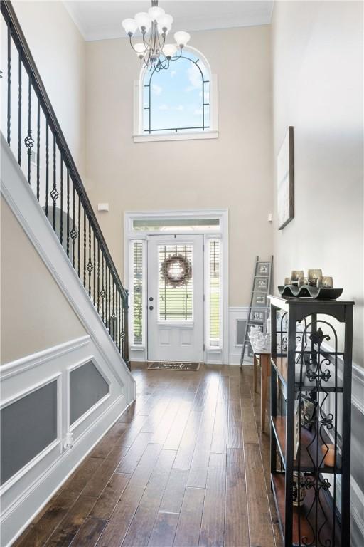 300 Holland Loop, Smiths Station, AL 36877 - foyer featuring a chandelier, stairway, wood finished floors, a towering ceiling, and plenty of natural light