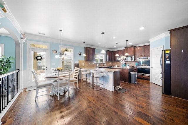 300 Holland Loop, Smiths Station, AL 36877 - dining room featuring dark wood-style floors, recessed lighting, ornamental molding, and arched walkways
