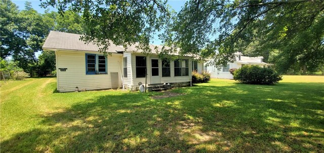 rear view of house featuring a lawn