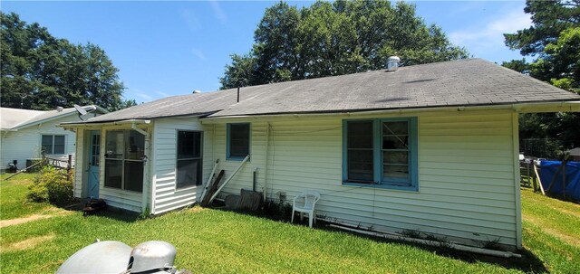 rear view of property featuring a lawn