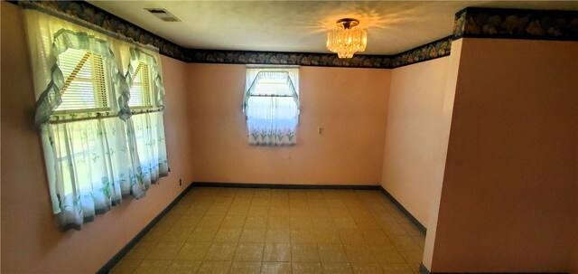 unfurnished room featuring an inviting chandelier