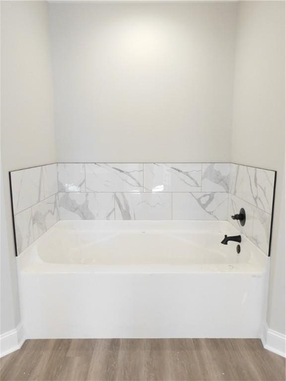 bathroom featuring hardwood / wood-style flooring and a tub