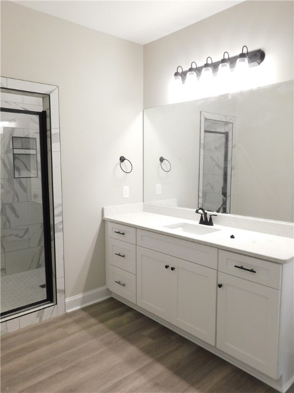 bathroom featuring hardwood / wood-style floors, vanity, and walk in shower