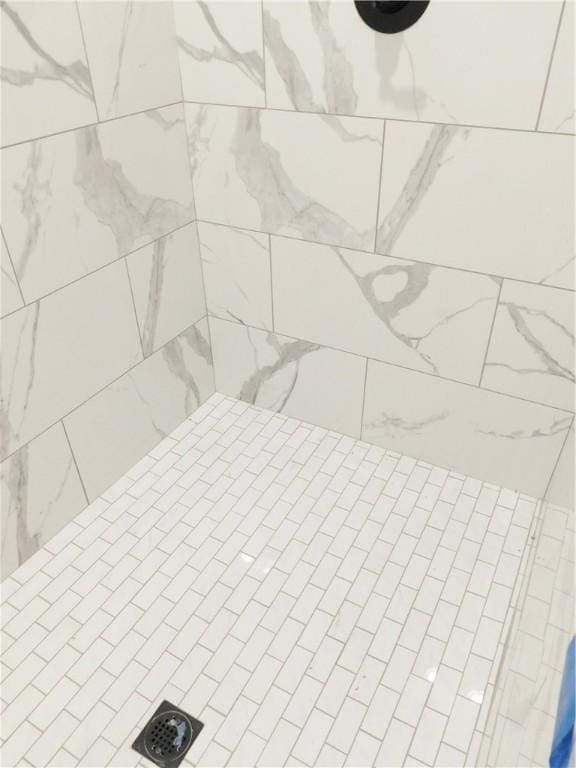 interior details with a tile shower