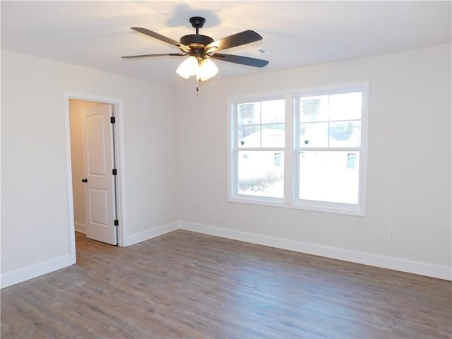 spare room with ceiling fan and dark wood-type flooring