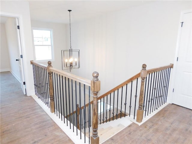 staircase featuring a notable chandelier and hardwood / wood-style flooring