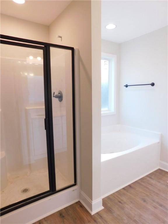 bathroom featuring shower with separate bathtub and hardwood / wood-style floors