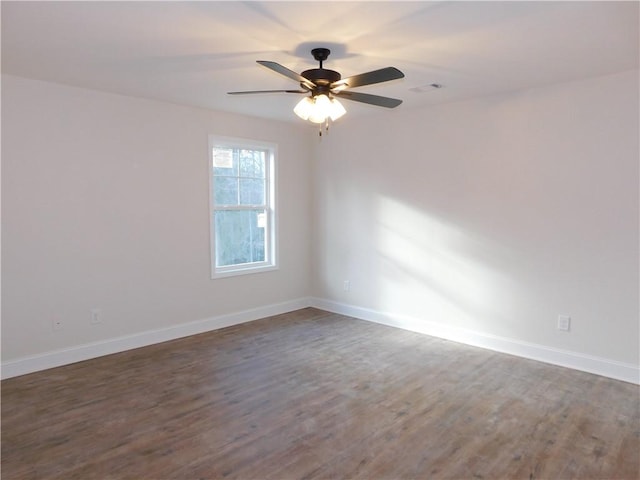 empty room with dark wood-type flooring and ceiling fan