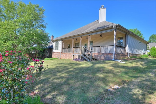 back of property featuring ceiling fan, covered porch, and a yard