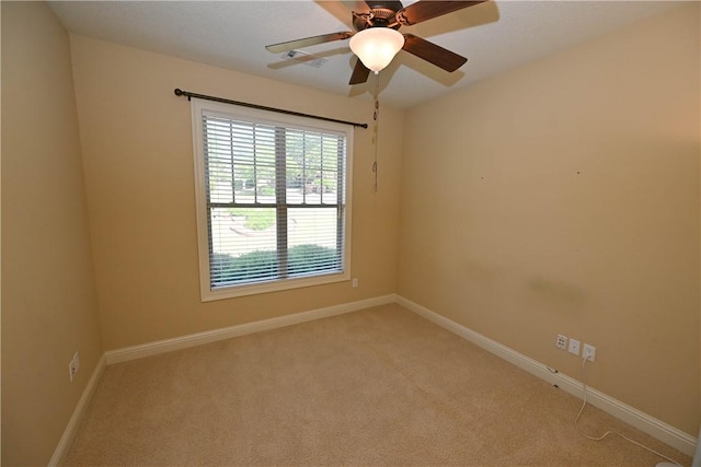 spare room with ceiling fan and light colored carpet