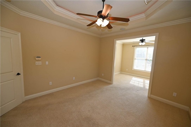 carpeted spare room featuring crown molding and a tray ceiling