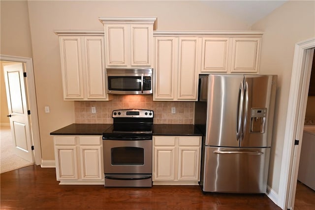 kitchen featuring cream cabinetry, appliances with stainless steel finishes, tasteful backsplash, and dark wood-type flooring