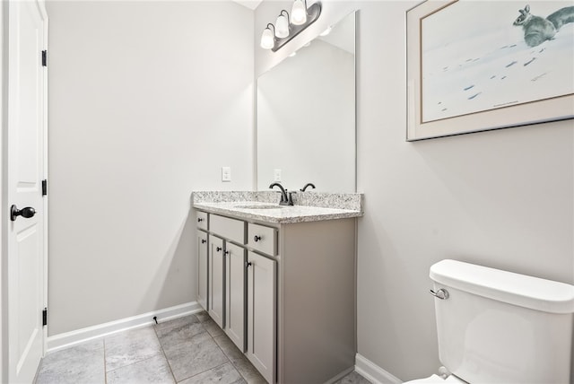 bathroom with toilet, vanity, and tile patterned flooring