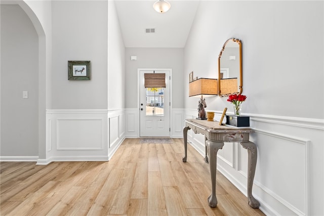 foyer entrance featuring vaulted ceiling and light hardwood / wood-style floors