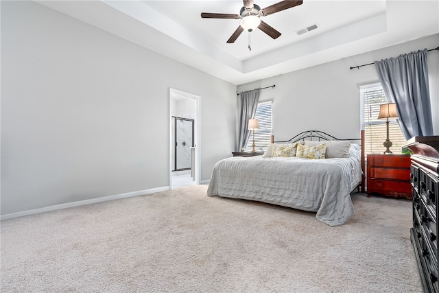 carpeted bedroom with ceiling fan and a raised ceiling