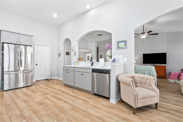 kitchen featuring appliances with stainless steel finishes, sink, light wood-type flooring, ceiling fan, and gray cabinets